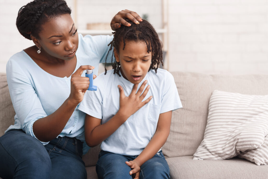 Asthma und Neurodermitis: Mutter hält Tochter Asthmainhalierer