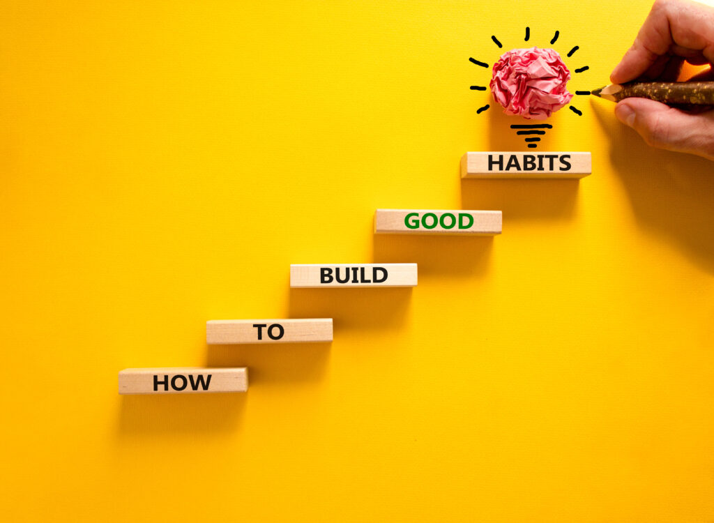 Bausteine mit der Aufschrift How to build good habits auf gelben Hintergrund
