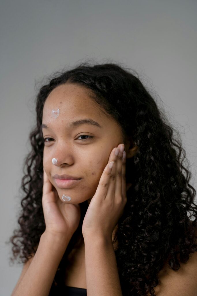 Frau mit Creme im Gesicht: Neurodermitis-Behandlung 